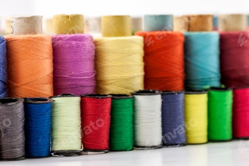 Preview: Reels or spools of multicolored sewing threads. Threads of all colors. Shallow depth of field. Close