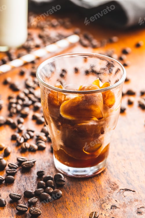 Preview: Frozen coffee shaped like heart. Coffee ice cubes in glass cup.
