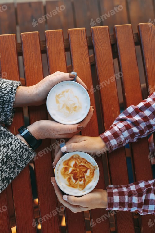 Preview: Woman hands with freckles holding cups of coffee