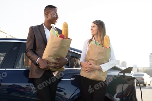 Preview: African man and Caucasian woman, having stop at charging station