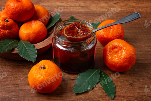 Preview: jar of tangerine jam, stands on a wooden table, with fresh tangerines,