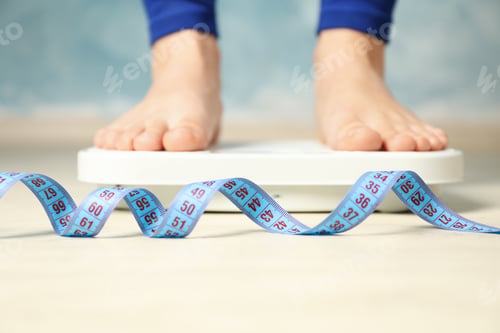 Preview: Woman stands on the scales. Measuring tape. Weight loss
