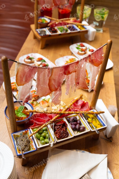 Preview: Antipasti in the restaurant, exquisite serving of meat appetizers, jamon, ham, salami, olives, sauce