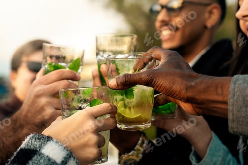 Visualização: Close-up de diversas mãos brindando com coquetéis de mojito em uma festa ao ar livre