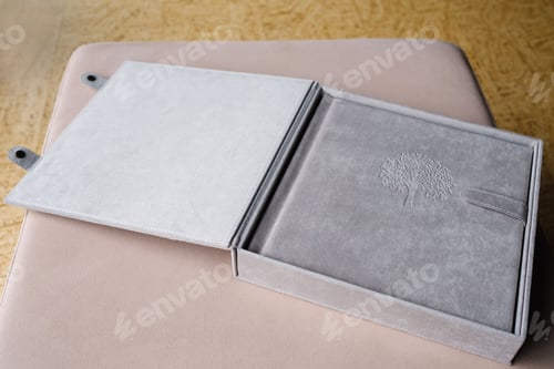 Preview: A photo book in a grey cloth cover lies on the box. the concept of creating books