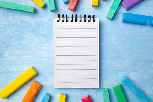Preview: Colorful chalks on blue background with copy space for text