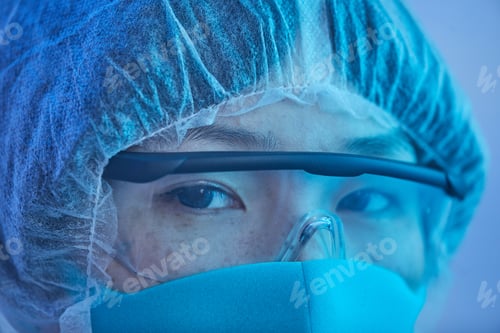 Preview: Asian female doctor in protective glasses