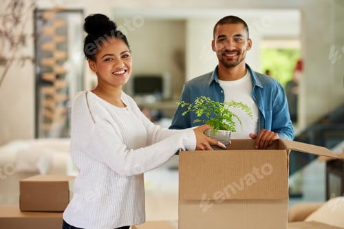 Preview: Portrait of a happy young couple unpacking boxes in their new home together