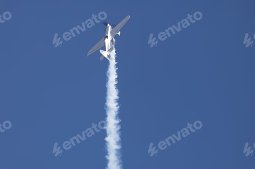 Preview: Aerobatic airplane performing a vertical climb with smoke trail.
