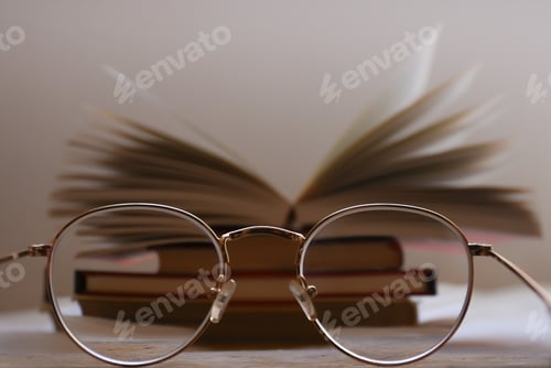 Preview: Books and Eyeglasses on Table in Soft Light