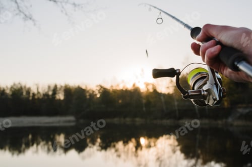 Preview: Fishing. Fisherman with rod, spinning reel on the river bank. Fishing for pike, perch, carp. Fog aga