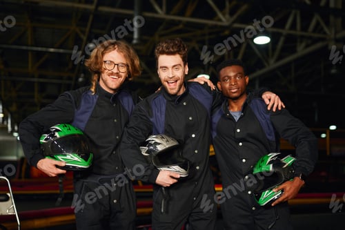 Preview: Enthusiastic Men Holding Racing Helmets in Go-Kart Track