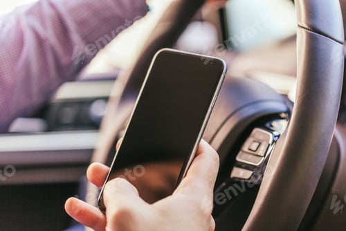 Preview: close up of young man hand with smartphone driving car