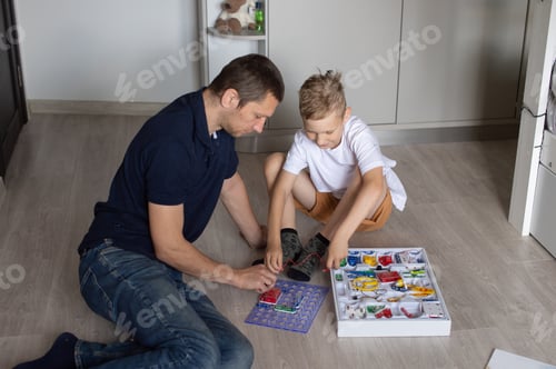 Preview: A cute boy in a white T-shirt collects an electrical designer with his dad in the room
