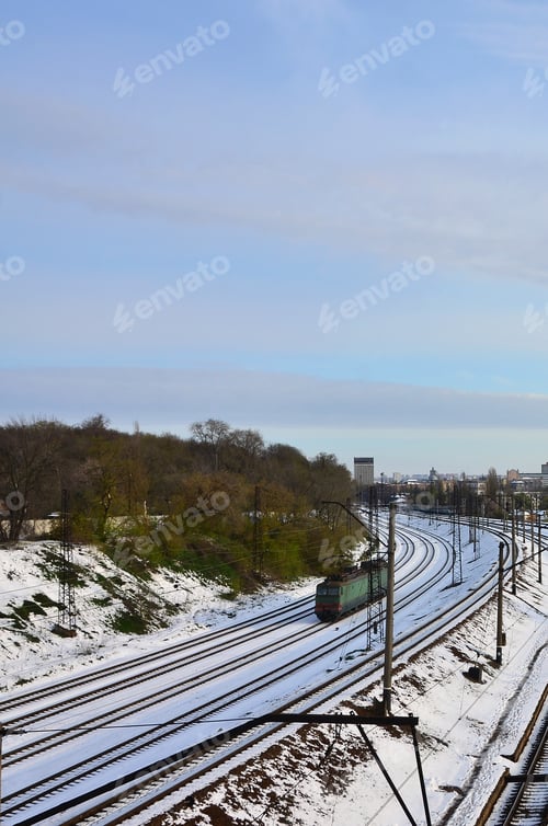 Preview: Winter landscape with a railway train against a cloudy sky background