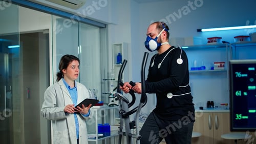 Preview: Slow motion shot of sport scientist looking at tablet with EKG scan