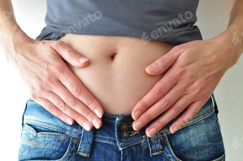 Preview: woman with rolled up t-shirt touching her bare belly with both hands