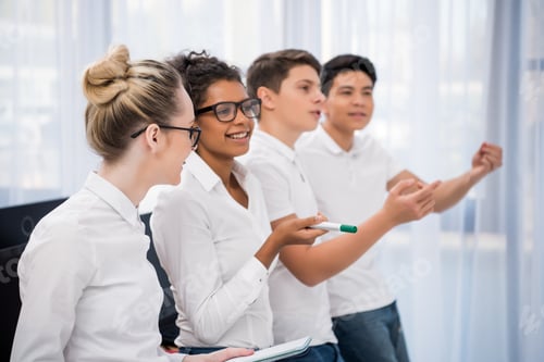 Preview: young multicultural students looking and pointing on something
