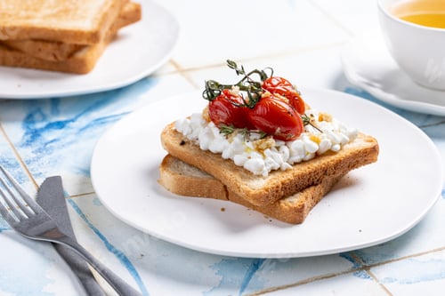 Preview: Toasted slices of bread with cottage cheese, roasted cherry tomatoes