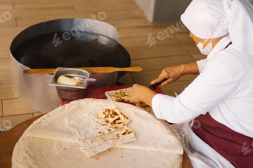Preview: Turkish Woman making Tortillas on a wooden rustic table.