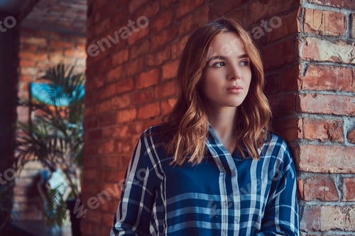 Preview: Close-up portrait of a young sensual girl leaning against a bric