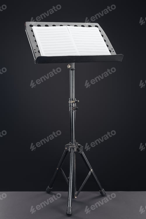 Preview: opened music book on stand on black background