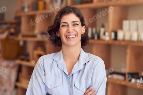Preview: Portrait Of Female Owner Of Gift Store Standing In Front Of Shelves With Cosmetics And Candles