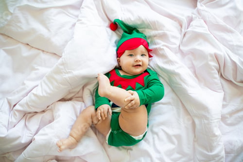 Preview: Cute caucasian baby girl six months old wearing elf costume green color.
