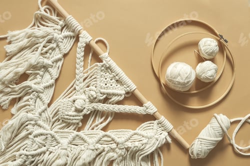 Preview: Macrame. Handmade macrame weaving and cotton threads on a rustic wooden stick.