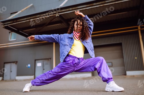 Preview: Funky young woman with american bandana dancing alone in the street.Sport, dancing and urban culture