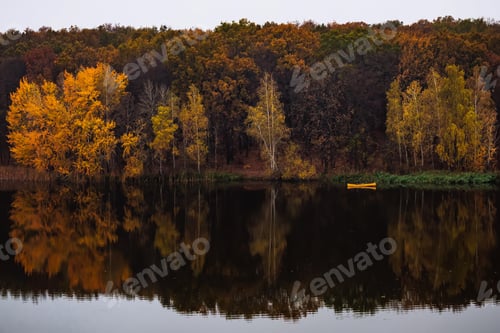 Preview: Yellow small boat near the forest with golden autumn trees
