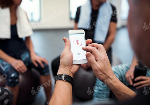 Preview: A midsection of group of seniors with smartphone in gym checking heart rate.