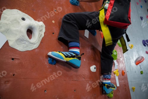 Preview: Boy practicing rock climbing in fitness studio