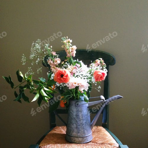 Preview: Floral Arrangement in Watering Can on Woven Chair
