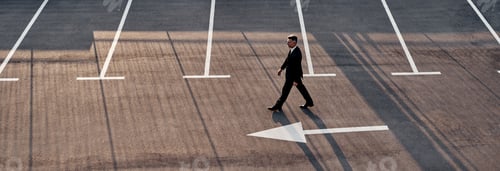 Preview: Top view of man in formalwear moving forward with arrow sign on the road