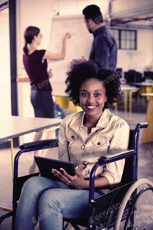 Preview: Portrait of smiling disabled business executive in wheelchair using digital tablet