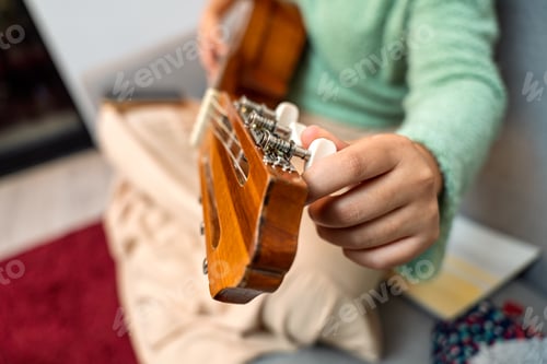 Preview: Singer songwriter tuning acoustic guitar at home studio
