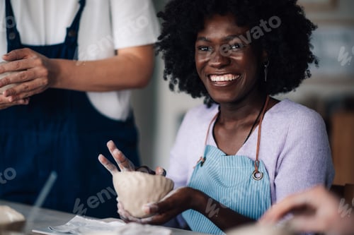Preview: Interracial pottery class student making earthenware at ceramics studio