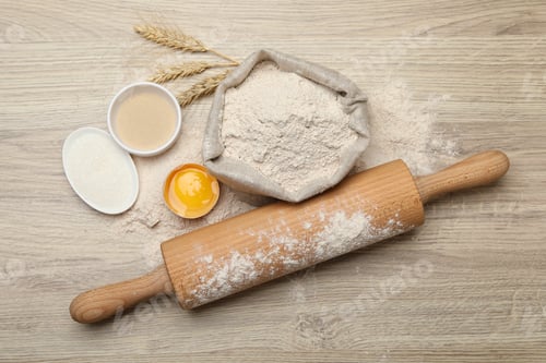 Preview: Rolling pin and different ingredients on light wooden table, flat lay