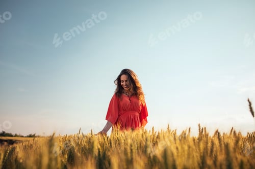 Woman in Field of Golden Wheat at Sunset