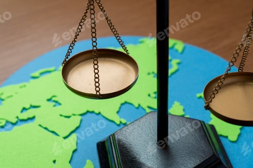 Preview: Brass scales of justice on a paper world map cutout.