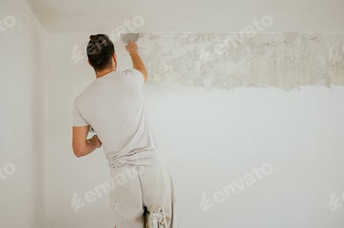 Preview: Rear view of a builder skim coating walls with plaster.