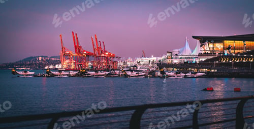 Preview: Wide-angle lens shot of a harbor with ships under a purple sky t night