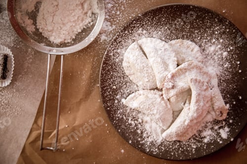 Preview: Closeup of Gazelle Horns dust with powdered sugar on a craft paper and a sifter