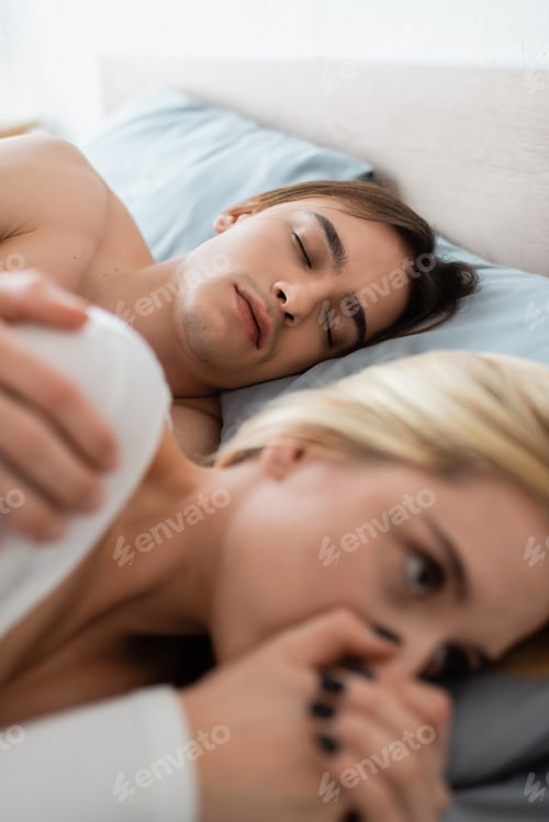 Preview: shirtless man sleeping with embarrassed blonde woman covering mouth after one night stand