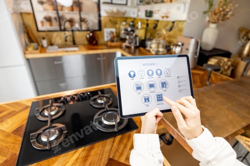 Preview: Woman holding digital tablet with running smart home application in the kitchen