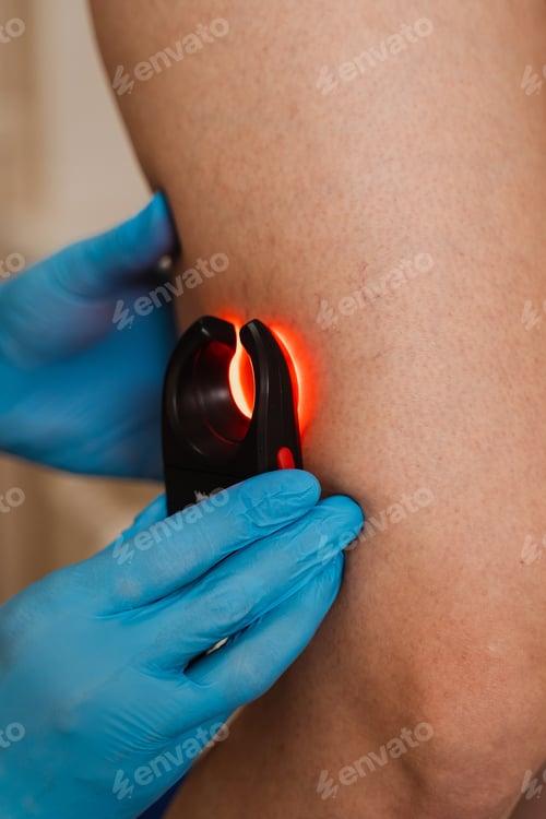 Preview: Vascular surgeon scans woman leg veins with LED venous scanner using red light for precision