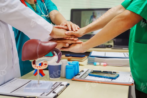 Preview: Three doctors join hands at a hospital table after meeting on liver disease,discussing conditions