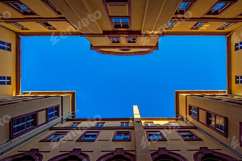 Preview: Low angle shot of an apartment building surrounded by a beautiful blue sky