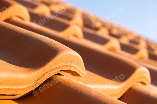 Preview: Overlapping rows of yellow ceramic roofing tiles covering residential building roof